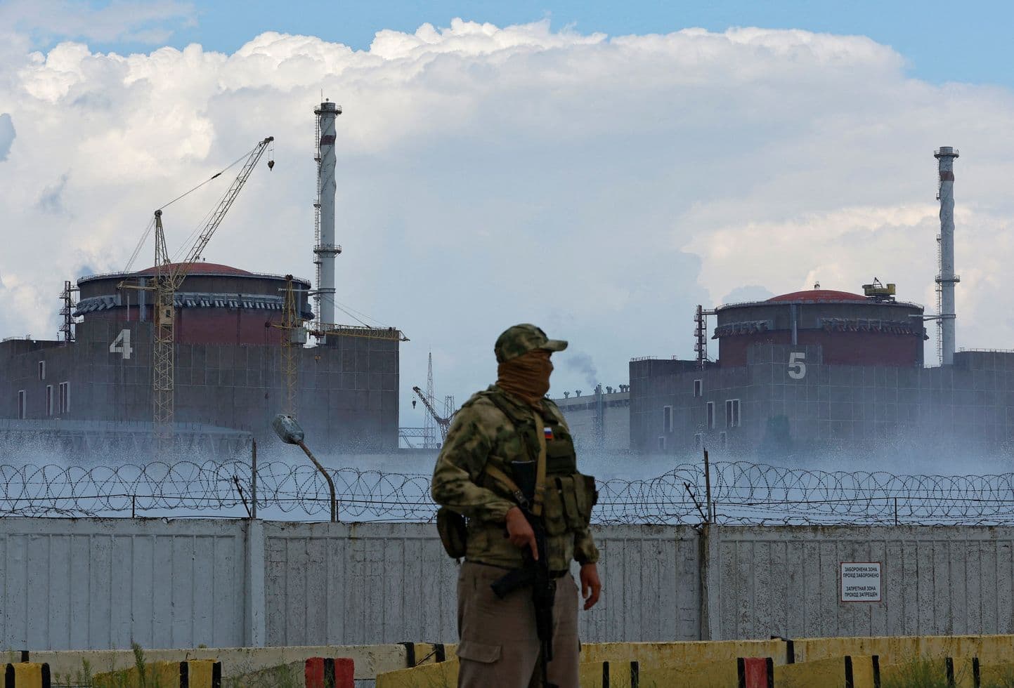 Российский военный на фоне Запорожской АЭС. Фото: Alexander Ermochenko / Reuters / Forum